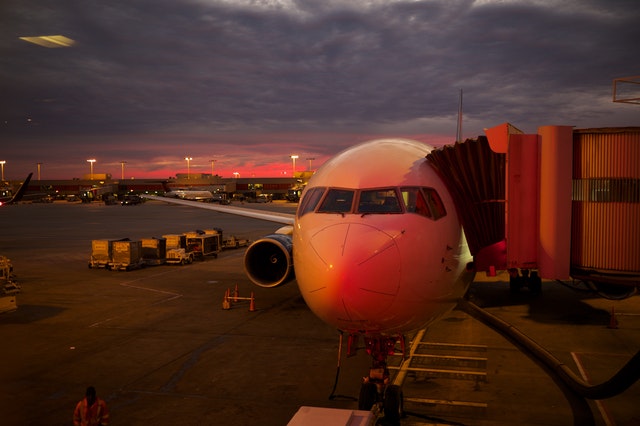 Lietadlo na letisku pripravené na nástup cestujúcich po západe slnka.jpg