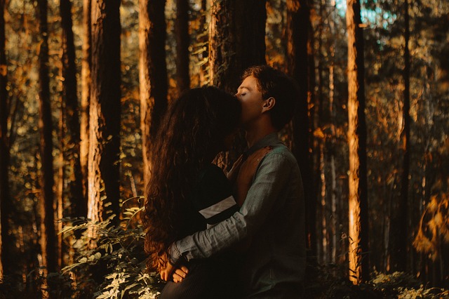 Muž objíma ženu a stoja v lese medzi stromami.jpg
