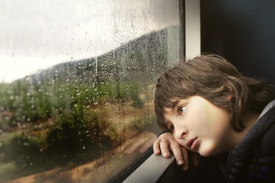 Chlapec pozerá z okna